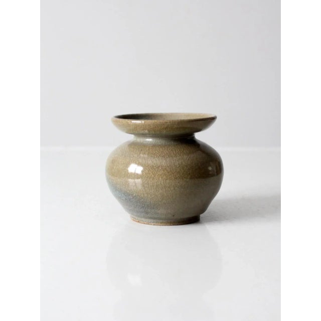 A vintage studio pottery vase, signed by the artist, featuring a beautifully handcrafted form and striking blue and tan...