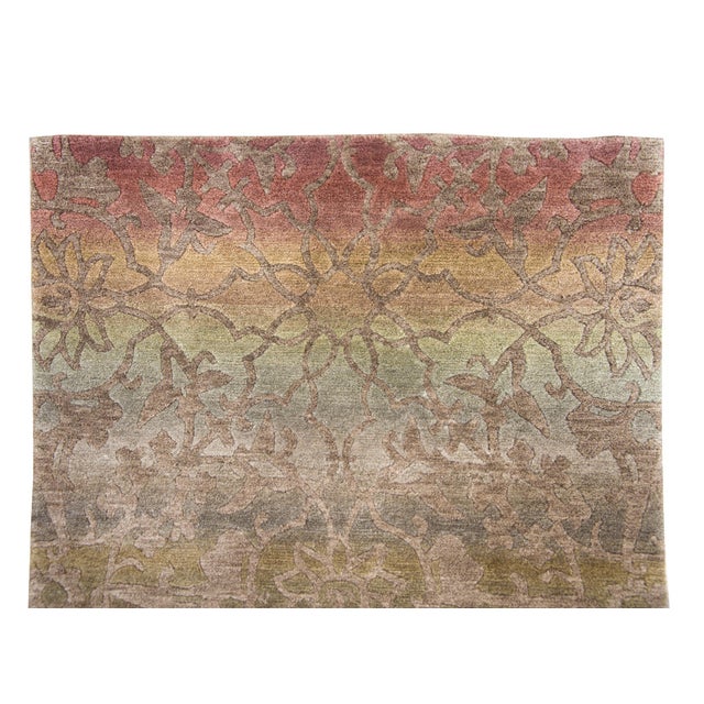 A sweet contemporary hand-knotted Tibetan rug with an ombré rainbow background overlaid with a central lotus flower...