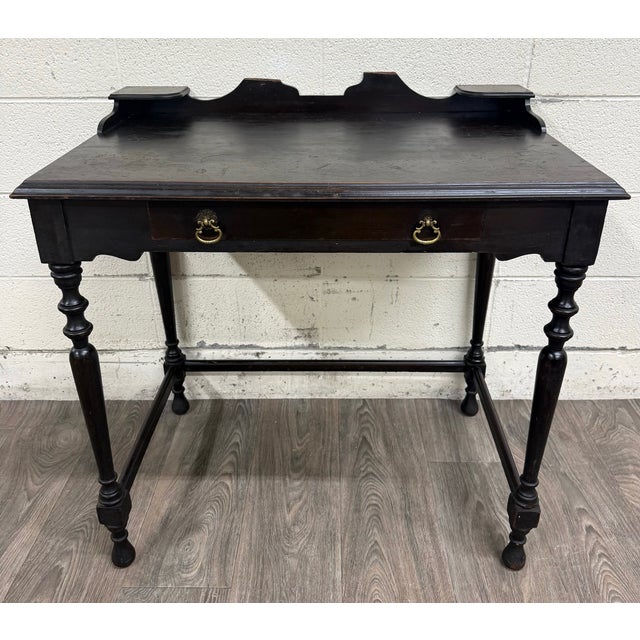 This is a stunning vintage William & Mary Revival mahogany writing desk featuring classic turned legs, a raised gallery...