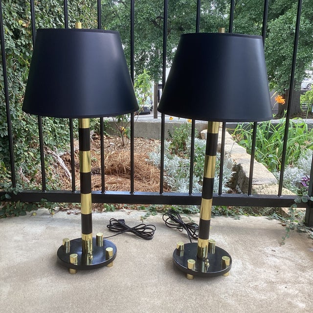 Elegant brass and black lamps, in the manner of Tommi Parzinger, American, circa 1950s. They have been rewired and are...