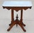 A beautiful late 19th-century American Victorian Eastlake marble top parlor table featuring a richly carved walnut base...