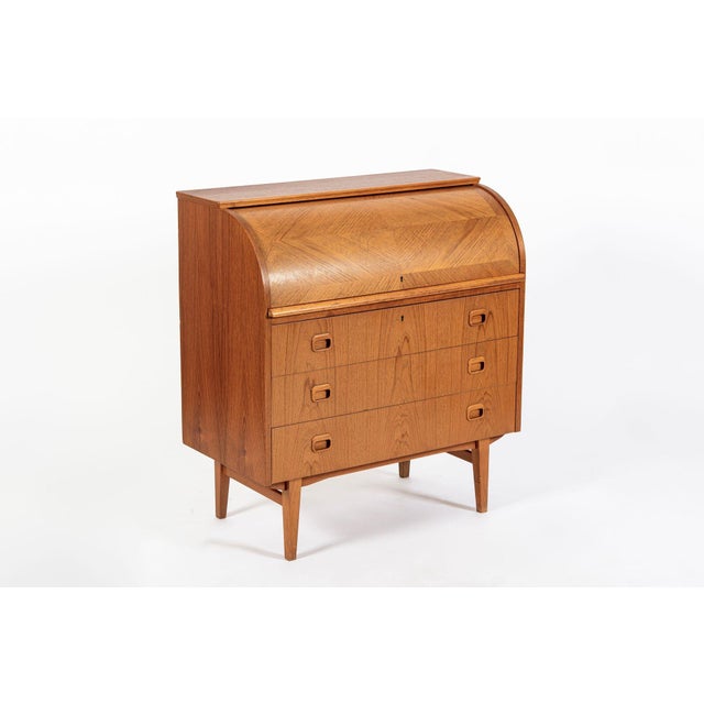This vintage mid-century Swedish modern Egon Ostergaard teak rolltop secretary desk cabinet was made in Sweden circa 1960....