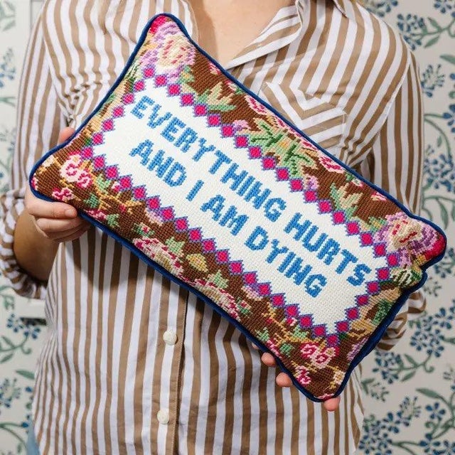 "Everything Hurts and I Am Dying" printed text decorative needlepoint pillow. Floral background and a dark blue velvet...