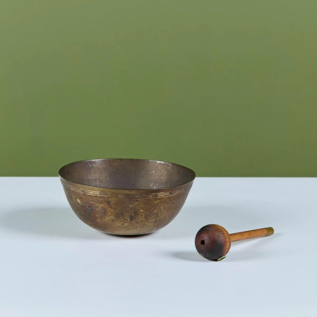 Patinated brass Chinese singing bowl c.1900's. The bowl etched with clouds, wind and mountain scenes, is accompanied by a...