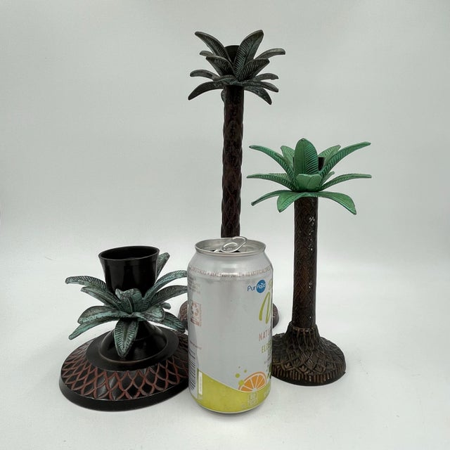 This is a fun, curated vintage set of three heavy metal palm tree candle holders, each with varying heights. The holders...