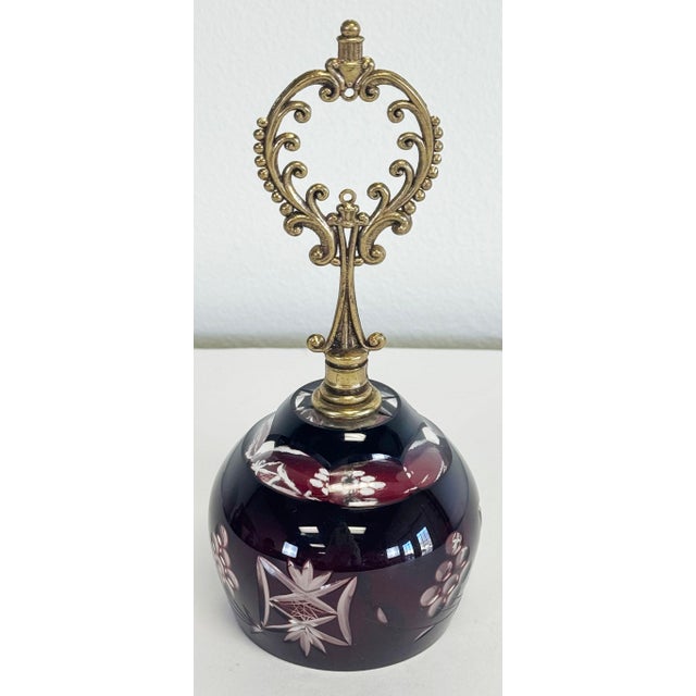 Stunning vintage Bohemian cut crystal bell with ornate brass handle. Rich ruby red tint to bell with clear etched design...