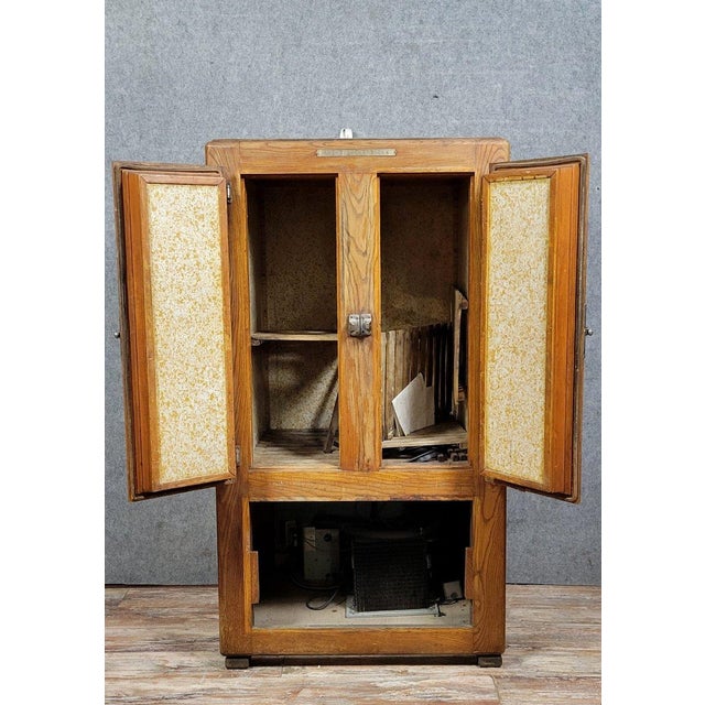 Prestcold brand bar fridge or store cooler in oak, circa 1930 Opens on the front with three doors Silver-plated metal...