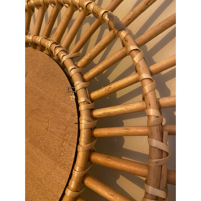A beautiful vintage-style rattan sunburst wall mirror, featuring an intricate handwoven design and a striking sculptural...