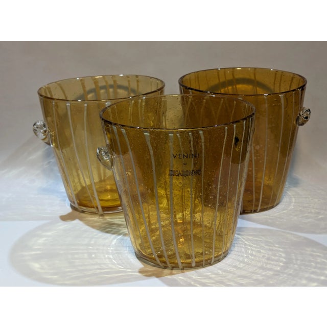 These are three Venini for Disaronno amber and white hand-blown ice bucket made in Murano, Italy in the 1970s. One still...