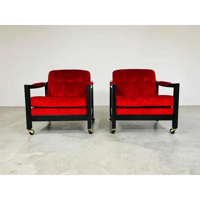 A pair of Mid-Century modern club chairs on casters by Directional in the manner of Milo Baughman having fresh deep red...