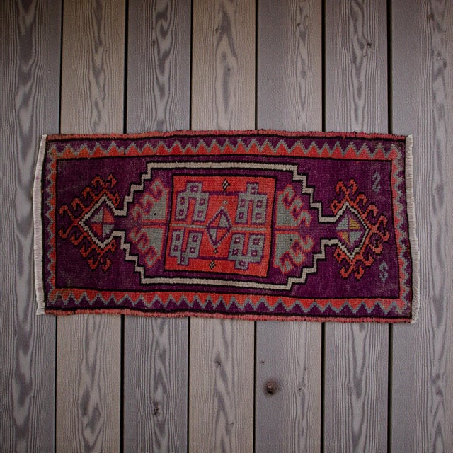 This authentic vintage Kars rug features a striking deep purple field adorned with vibrant terracotta and cool grey...