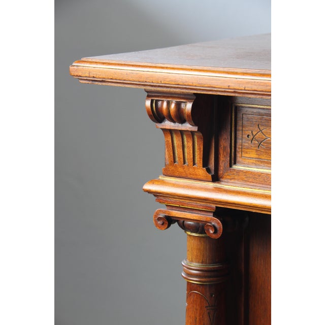 This wood cabinet, adorned with intricate carvings, is a splendid antique piece from the late 1800s to early 1900s in...
