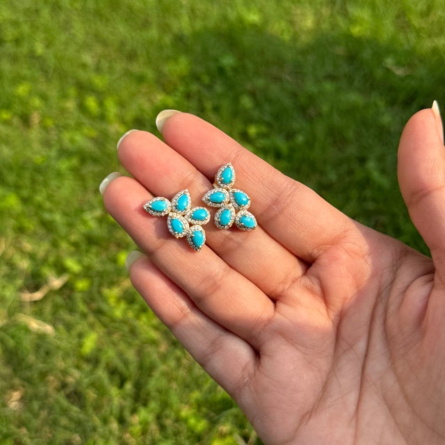 These cluster stud earrings feature 2.29 carats of natural turquoise set in 14K yellow gold. Each turquoise cabochon...