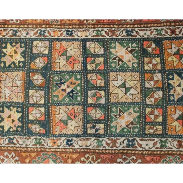 An early 20th Century Persian Kurdish runner with multiple geometric floral medallions surrounded by wonderful wide...