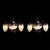 A striking pair of two-arm wall sconces in dark wrought iron, adorned with hand-cut vine leaves and pendant clusters of...