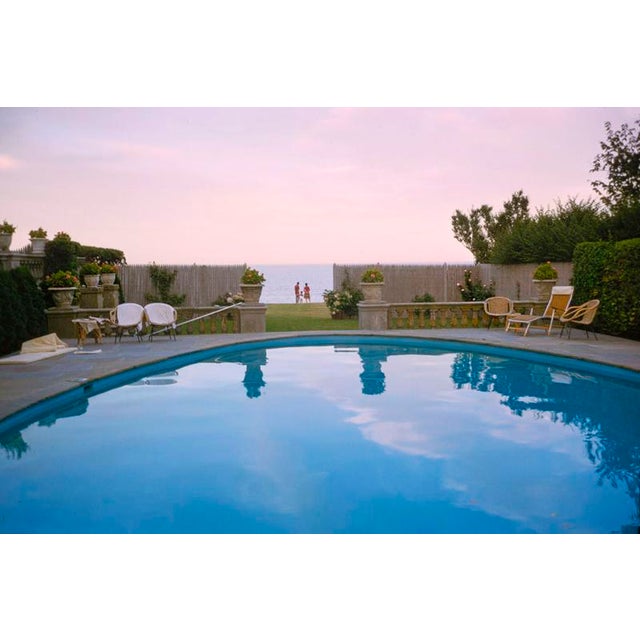 Sunset By The Pool by Toni Frissell People watch the sunset over the ocean while standing by a swimming pool, 1962 (Photo...