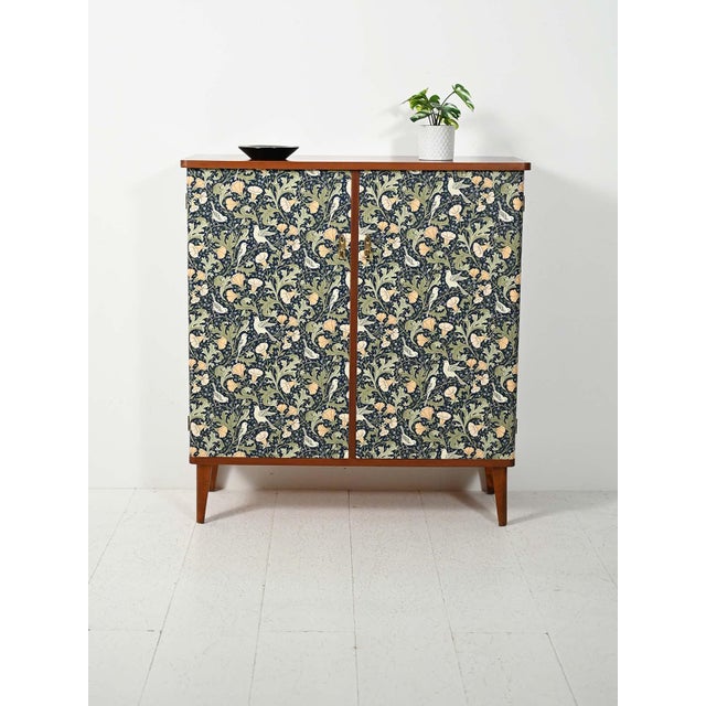 1950s cabinet with doors covered in decorative Arts & Crafts-style paper and original brass handles. Scandinavian cabinet...