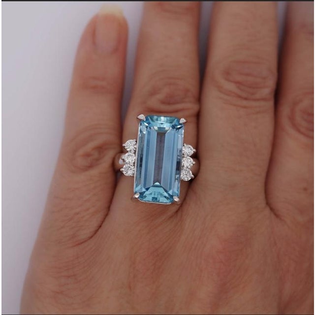 GIA certified 16.70-carat emerald-cut aquamarine at its center, accented by 0.69 carats total weight of round-cut diamond...
