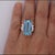 GIA certified 16.70-carat emerald-cut aquamarine at its center, accented by 0.69 carats total weight of round-cut diamond...