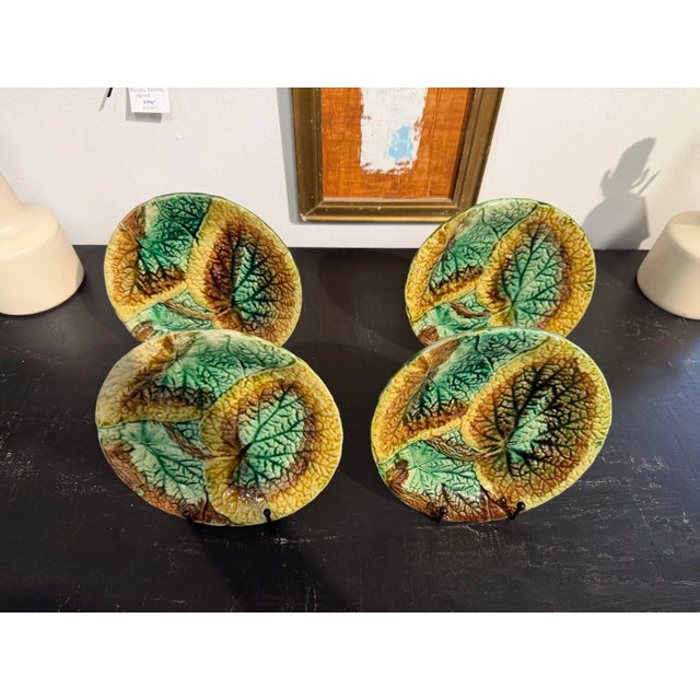 This is a set of 19th-century Majolica plates featuring a vibrant begonia leaf pattern. These plates are highly textured,...