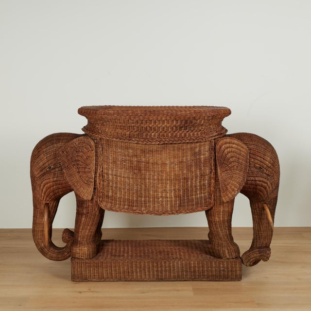 Whimsical mid century bar hand crafted in stick wicker featuring a serving surface on top over a two headed elephant with...