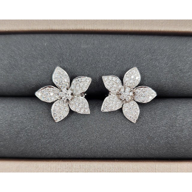 These stunning flower-shaped earrings feature 142 brilliant diamonds, totaling 1.48 carats. The diamonds are E/F in color...