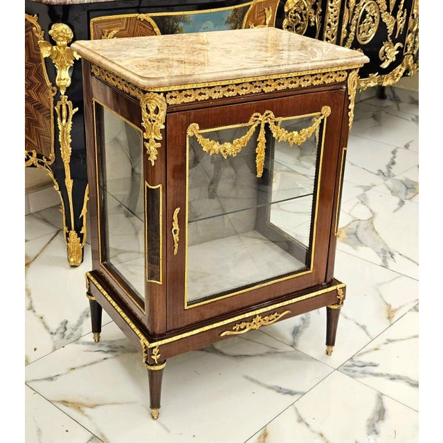 This elegant Louis XV-style marquetry bedside cabinet showcases refined French craftsmanship with a sophisticated blend of...
