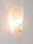 A single beautiful brass wall light with a lampshade made of solid textured melting ice glass with nice knobs....