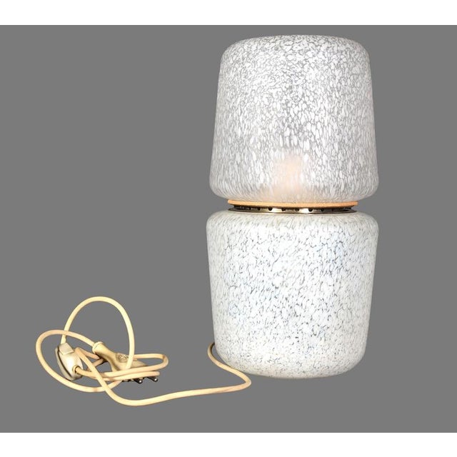 This vintage table lamp is a refined design lamp manufactured in Italy in the 1960s. White ceramic table lamp whose soft...