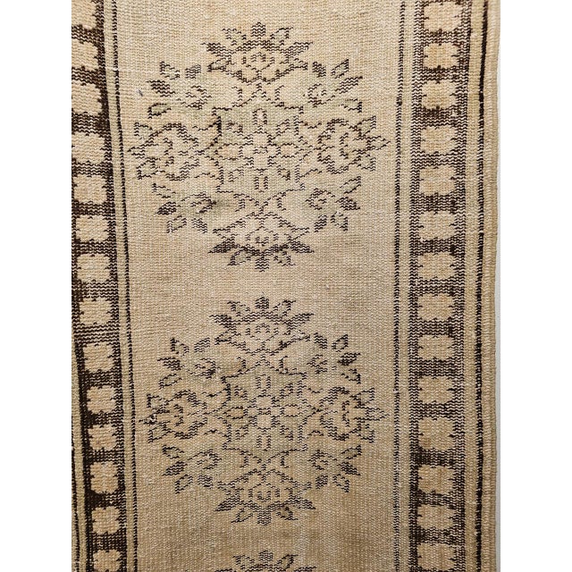 A vintage Turkish Oushak runner from the second quarter of the 20th century, featuring a refined multiple medallion design...