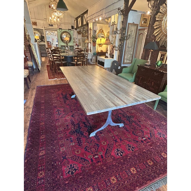Sleek industrial flooring used in this artisan custom crafted dining table, having a grey and light brown soft sand...