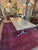 Sleek industrial flooring used in this artisan custom crafted dining table, having a grey and light brown soft sand...