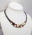 1980s gunmetal with Mondrian inspired white, red and dark grey metalic enamel pattern on the front of the collar necklace...