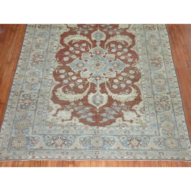 Antique Persian Tabriz rug with a burgundy field, predominant accents in icy blue and gray found in the medallion, field...