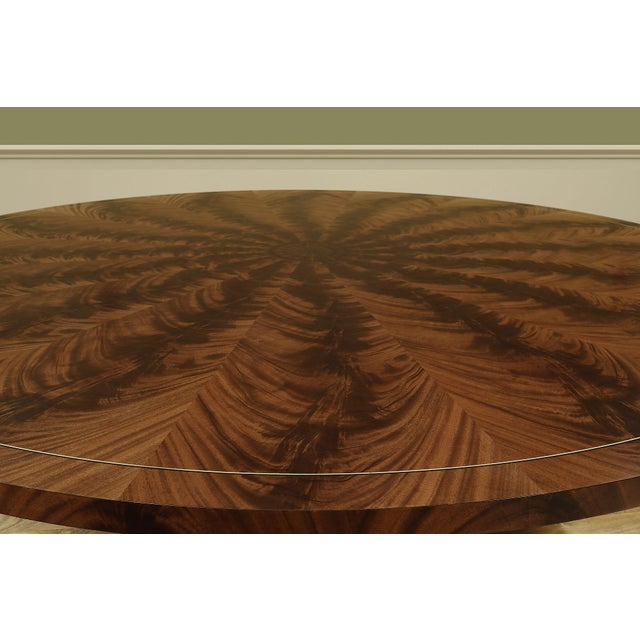 90" round flame mahogany dining table. A 1.5" thick flame mahogany tabletop with an outswept Duncan Phyfe pedestal and...