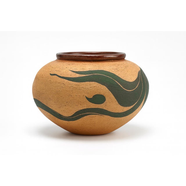 A rounded Arne Pottery vase from Flagstaff, Arizona, with a wide shoulder that narrows at the mouth. Cream hues create...