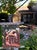 Morning Nook by Tracy Wall | Oil on canvas depicting a cozy house in a garden setting. For Sale