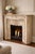 A substantial antique French fireplace surround cast in iron and finished in a weathered faux-limestone paint treatment,...