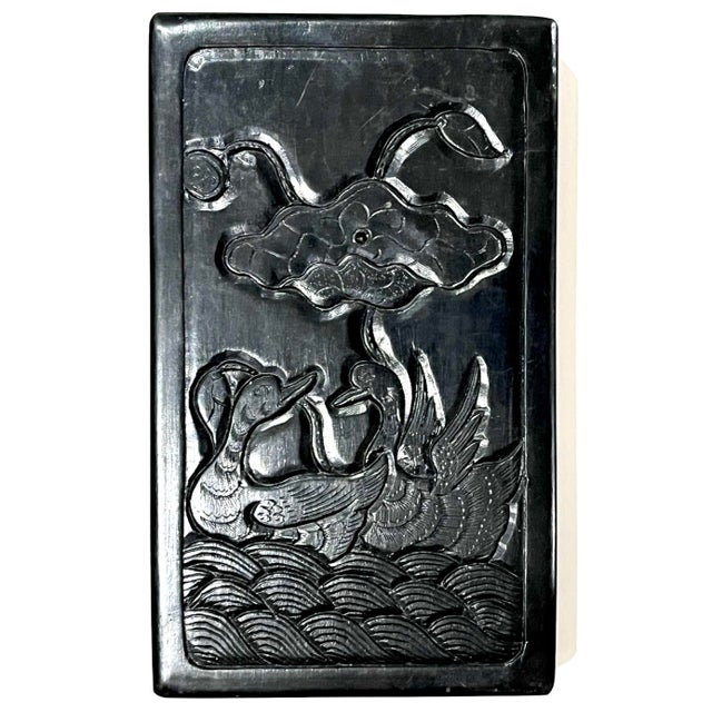 This 19th century Qing Dynasty ink stone box features a carved top with a lotus blossom and pair of Mandarin ducks....
