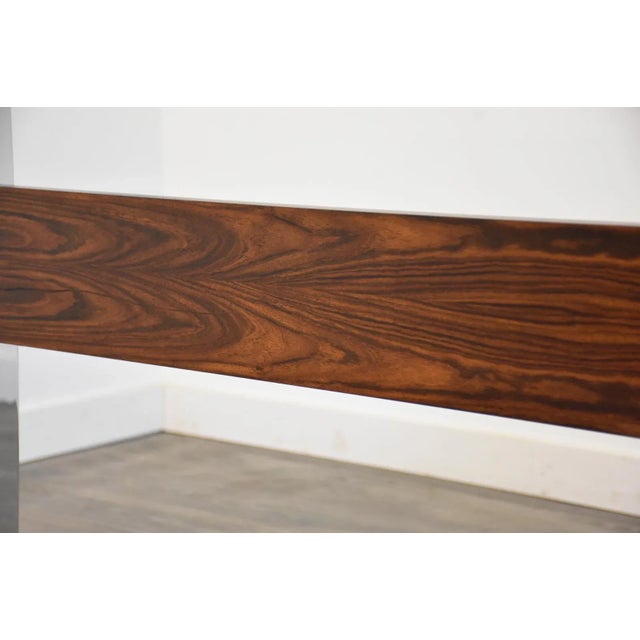 A mid century modern chrome dining table with a rosewood stretcher and glass top. One minor chip in the glass underneath....