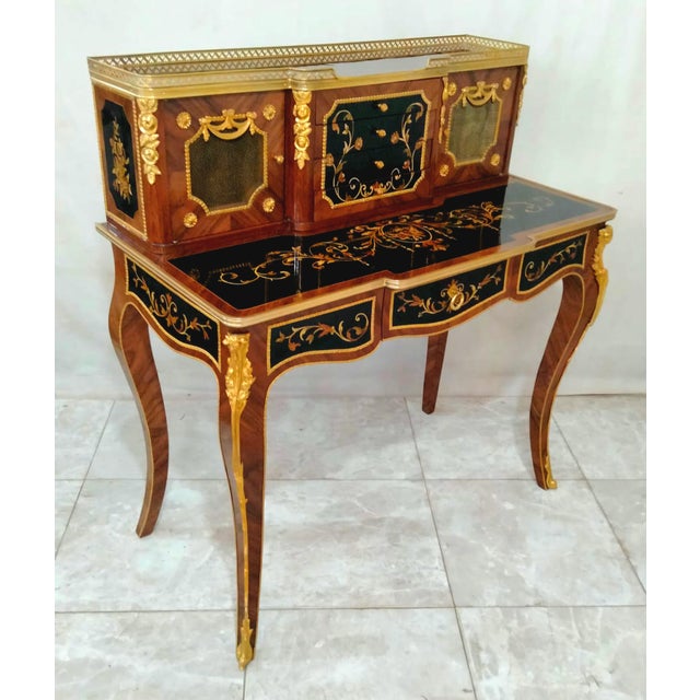 Bring refined European elegance to your workspace with this French Louis XV-inspired writing desk, featuring a rich...