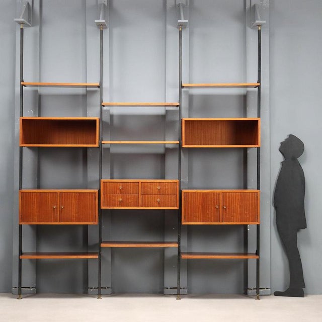 This floor-to-ceiling bookcase, requiring the uprights to be anchored to the ceiling, features adjustable open shelves,...