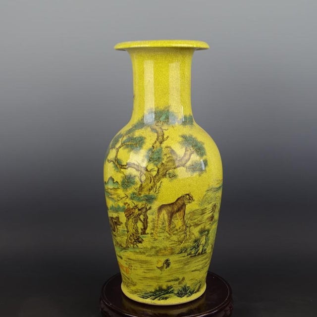 Expertly crafted during the Qing Dynasty, this Chinese Ceramic Vase features a Qianlong mark and striking yellow ground...