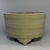 A vintage‑style Chinese Longquan celadon tripod censer, standing on three short feet. Horizontal raised band decorations...