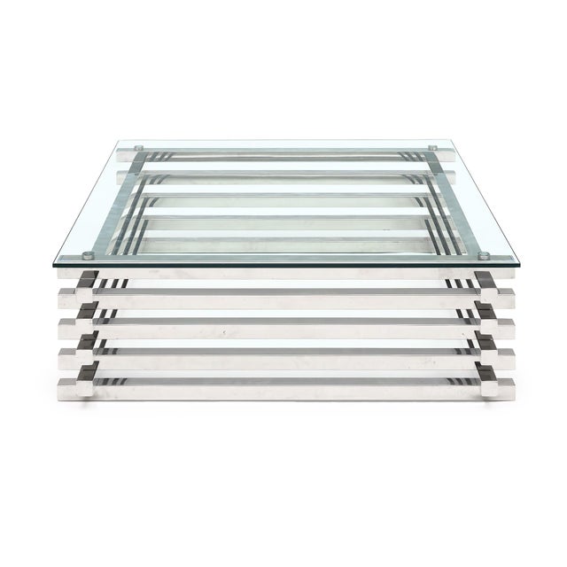 Square coffee table with a stacked chrome base from the period mid-century modern era in France. This piece has a glass...
