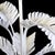 A petite white chandelier dripping with faux bamboo leaves — a jewel of a light fixture for a powder room, breakfast nook,...