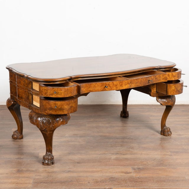 19th-century rococo desk crafted in walnut with veneer and darker trim detailing along the desk top edge. The desk is...