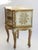 An Italian chest of drawers with white and golden details. The vintage Florentine chest has two drawers that open with...