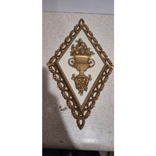 Set of four vintage Homco diamond-shaped wall plaques, dated 1971, in gold-tone ornate scrollwork frames on cream backing....