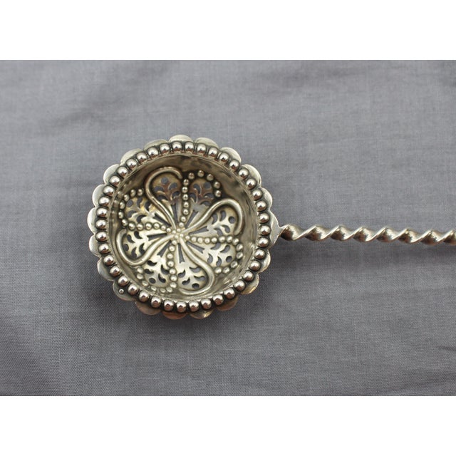 Sterling silver sifting ladle, Sheffield, England, 1894. Fun East Midlands Imp adorns the tip. Twisted handle (folklore...
